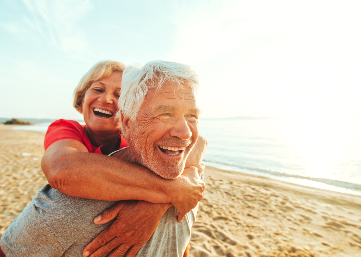 Older couple hugging on the beach